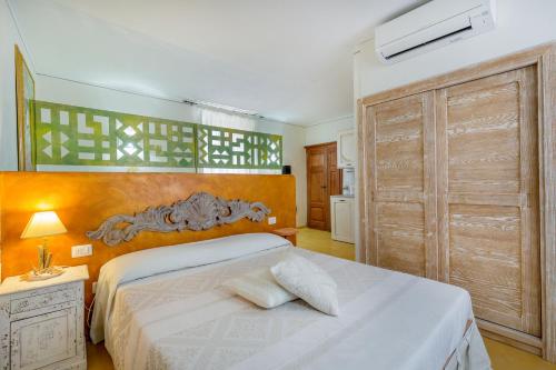 a bedroom with a bed and a large wooden closet at palazzo beddoro charming apartments in San Pantaleo