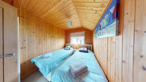 a bedroom with a bed in a wooden cabin at C29 Regwin, Riviere Towans in Hayle