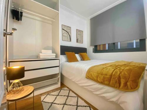 a white bedroom with a bed and a dresser and a window at Central Urban Elegance in Barcelona