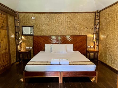 a bedroom with a bed with two towels on it at Babaland in New Agutaya