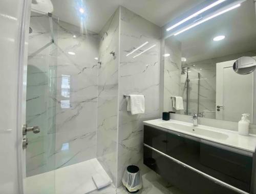 a bathroom with a shower and a sink and a mirror at Central Urban Elegance in Barcelona