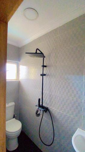 eine Dusche in einem Badezimmer mit Toilette und Waschbecken in der Unterkunft Plot1 Suits in Ibadan