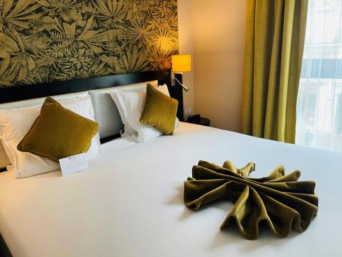 a hotel room with a bed with a bow on it at Best Western Allegro Nation in Paris