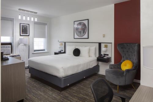a hotel room with a bed and a chair at Ramada by Wyndham Jersey City in Jersey City