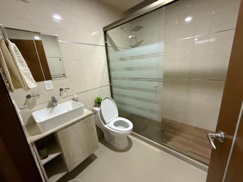 a bathroom with a toilet and a sink and a shower at Modern and Cozy Home in Acayuca