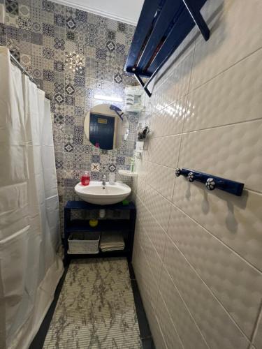 a small bathroom with a sink and a mirror at Будиночок над річкою in Korchin