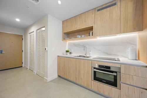 a kitchen with wooden cabinets and a sink at Prime Location Studio Steps from Top Attractions in Miami