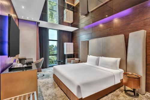 a hotel room with a bed and a desk at Radisson Blu Atria Bengaluru in Bangalore
