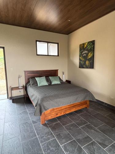 a bedroom with a bed and a window at Finca Las Raíces Posada Rural in Zarcero