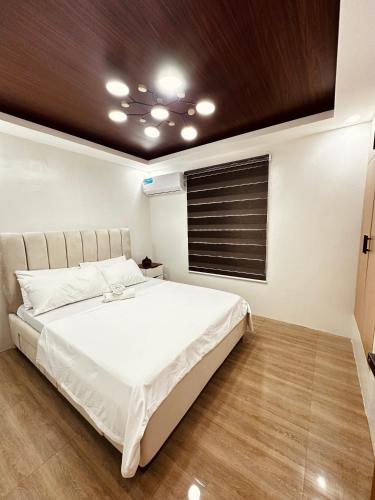 a bedroom with a white bed with a wooden ceiling at Casa Terrazza Marteja in Malolos
