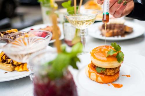 een tafel vol borden met eten en een sandwich bij The Saints Sutor Hotel in Breda