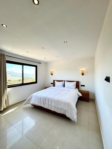 a bedroom with a large bed and a large window at Dar Youba, Luxe Villa Taghazout in Taghazout
