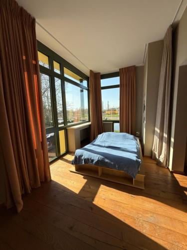 a bedroom with a bed and a large window at Villa Francine in Deinze