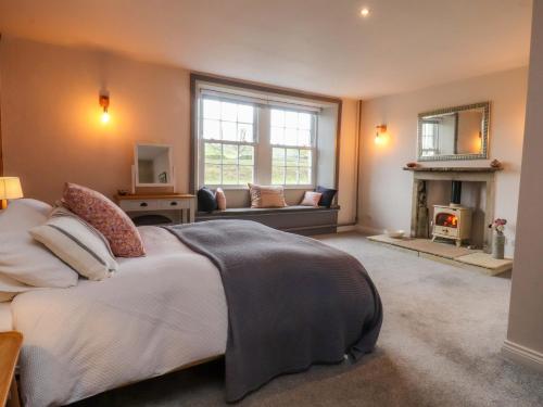 a bedroom with a bed and a living room with a fireplace at Kirk Yett in Skipton
