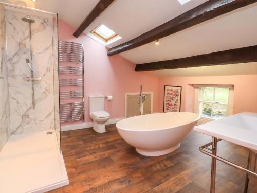 a bathroom with a large tub and a toilet at Kirk Yett in Skipton