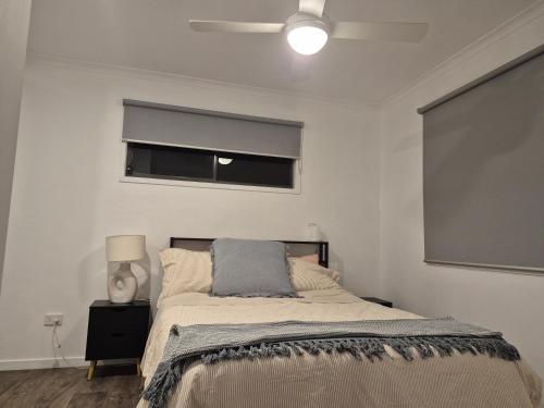 a bedroom with a large bed with a window at Convenient Getaway Home in Strathpine in Strathpine