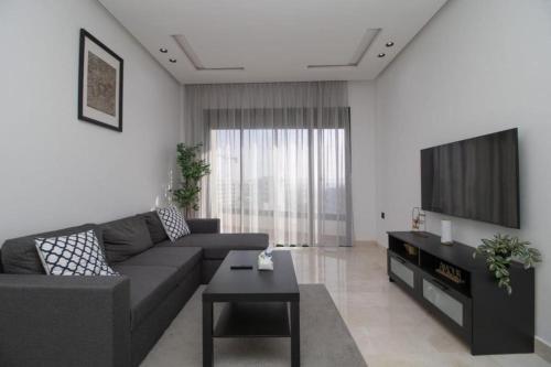 a living room with a couch and a tv at Bright Cozy Escape Walk to CFC Self Check-in in Oulad Akkou