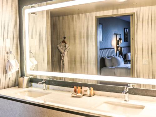 a woman is standing in front of a bathroom mirror at Hollywood Casino at Greektown in Detroit