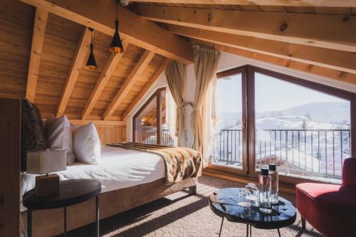 a bedroom with a bed and a large window at Hôtel Daria-I Nor by Les Etincelles in L'Alpe-d'Huez