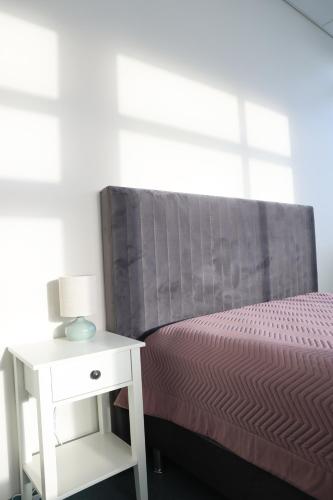 a bedroom with a bed and a nightstand with a lamp at Gistiheimilið Ósbær in Blönduós