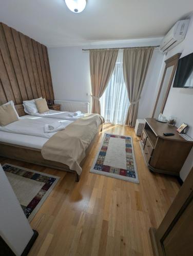 a hotel room with a bed and a desk and a bed and a room at Mateo Transalpina in Săsciori