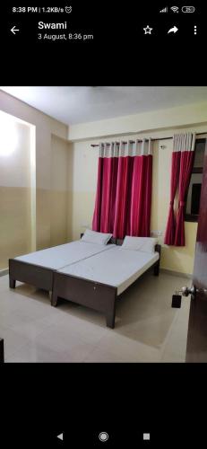 a bedroom with a large bed with red curtains at G d palace in Gwalior