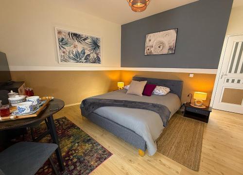 a bedroom with a bed and a table in it at Chambres d'hôtes "Le Clos de la Baie" in Paimpol
