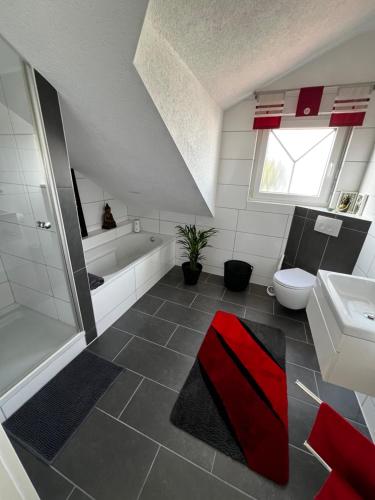 a bathroom with a tub and a toilet and a sink at Heimglück mit Ipf & Ruine in Bopfingen