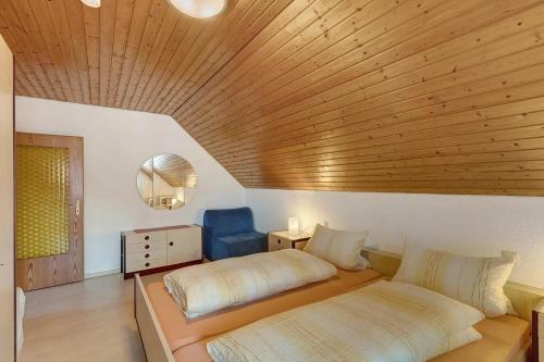 a bedroom with two beds and a wooden ceiling at Ferienwohnung Ettenheim in Ettenheim