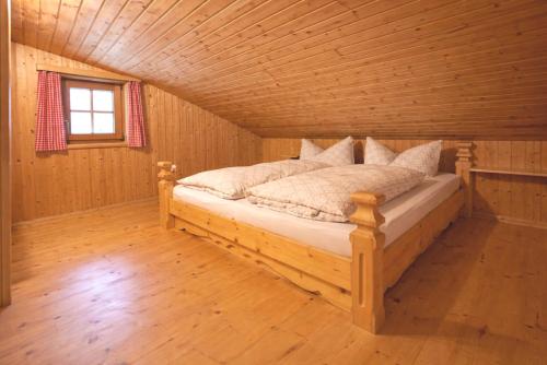 a bedroom with a bed in a wooden cabin at Almhütte Santnerhof - Hochgebirgshütte 1750m - This is a remote high mountain hut in Virgen