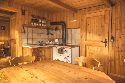 a wooden kitchen with a wooden table and a stove at Almhütte Santnerhof - Hochgebirgshütte 1750m - This is a remote high mountain hut in Virgen