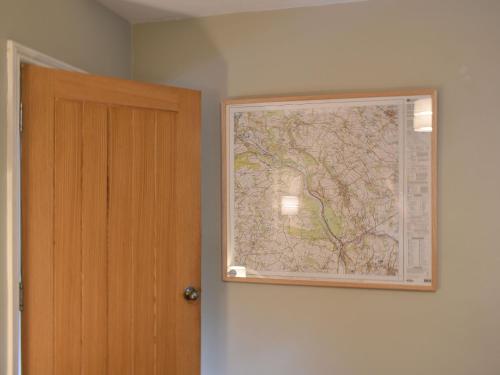 a large map on a wall next to a door at Vine Cottages in Crich