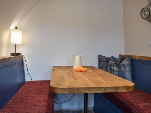 a wooden table with two oranges on top of it at Vine Cottages in Crich