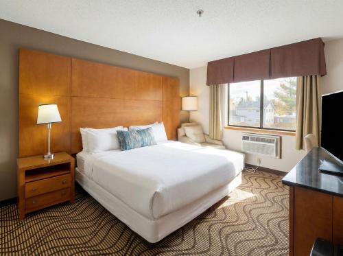 a hotel room with a large bed and a window at Oscoda Lakeside Hotel in Oscoda