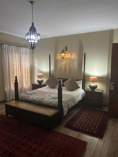 a bedroom with a bed and two lamps and a rug at Willows Boutique Hotel in Pretoria