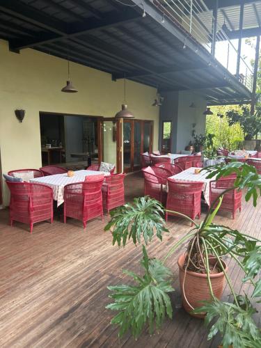 a restaurant with red chairs and tables and a tableablish at Willows Boutique Hotel in Pretoria