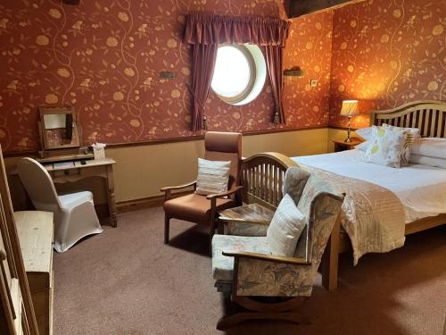 a bedroom with a bed and a chair and a window at The Dog and Partridge in Langsett