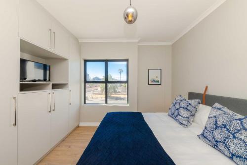 a bedroom with a bed and a tv at Cape on Porterfield in Cape Town
