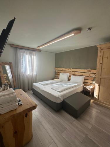 a bedroom with a large bed and a table at Chalet Margoni in Canazei
