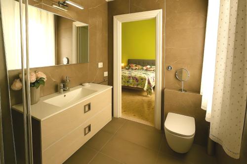 a bathroom with a sink and a toilet and a bed at Camera Verde vicino alle Mura - Madame Fannj in Lucca