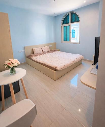 a bedroom with a bed and a table and a tv at Leo'J Hotel & Apartment in Phú Quốc