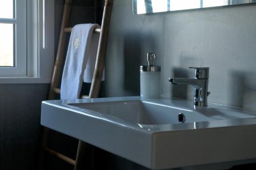 a white sink in a bathroom with a window at Quinta do Caritel in Vouzela