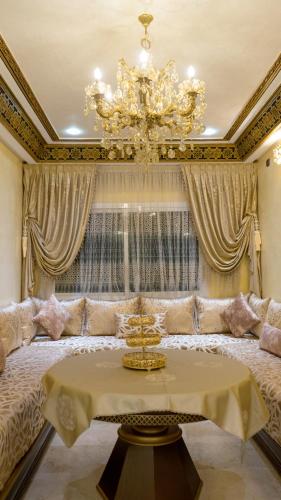 a living room with a large bed and a chandelier at Appartements Luxe Simo in Fez