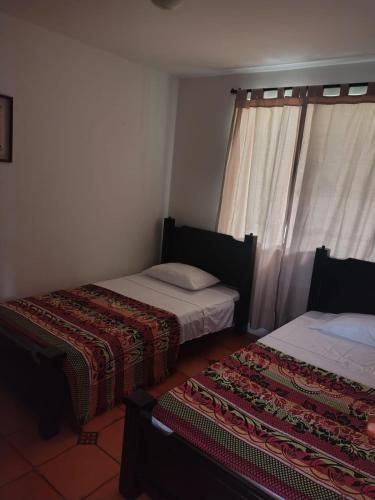a bedroom with two beds and a window at CAMPESTRE VILLA LUNA Quinbaya in El Tigre