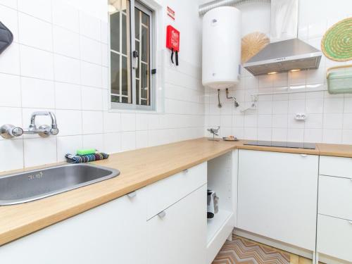 a kitchen with white cabinets and a sink at Paço no Monte by Stay ici in Montargil