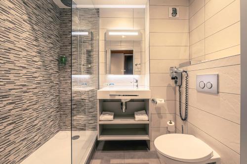 a bathroom with a toilet and a sink and a shower at Best Western Marseille Aeroport in Vitrolles