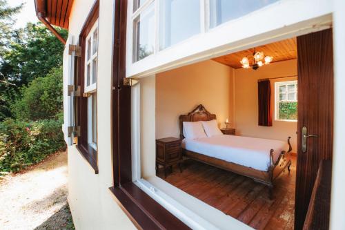 a bedroom with a bed and a window at Casa da Avó Lina by Quantique in Vieira do Minho