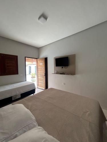a bedroom with a bed and a flat screen tv at Recanto da Lapinha in Piranhas