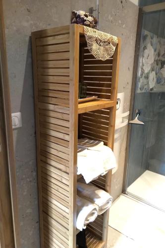 a wooden shelf in a bathroom with towels on it at Mas des Treilles - Chambre d'hôtes "Côté Villages" in Mane