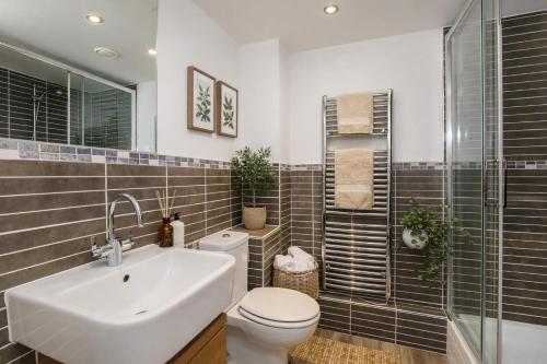 a bathroom with a sink and a toilet and a shower at Dixon's Yard, City Centre - Free Parking in York